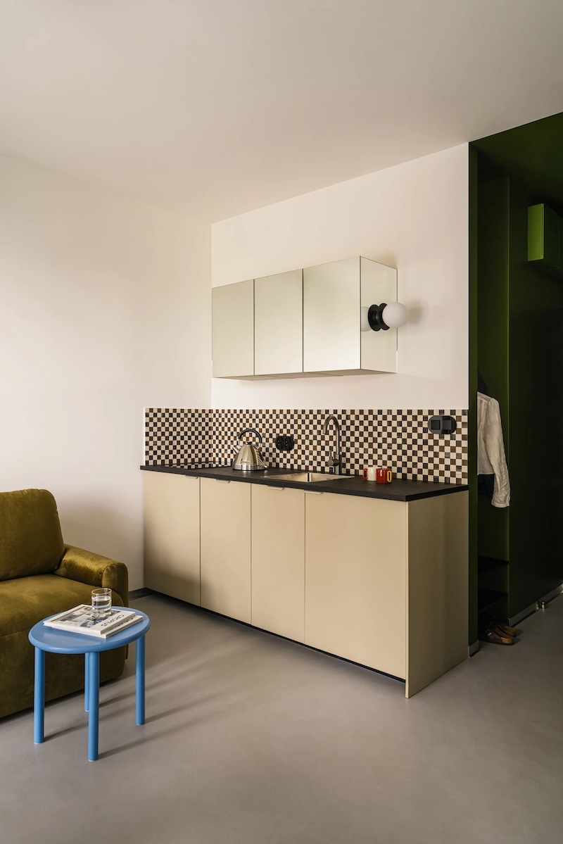 Kitchen by Wojtyczka Pracownia Projektowa with brown and white checkerboard tiles and a mirrored cabinet